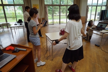 3Dスキャナでランドセルを計測する児童と本学学生