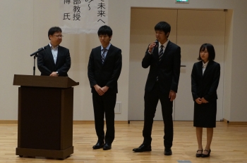 取組について説明する田中教授と代表の企業情報学部の学生